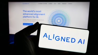 Stuttgart, Almanya - 02-19-2024: İngiliz yapay zeka şirketi Aligned Al 'in logosuna sahip akıllı telefon sahibi kişi web sitesinin önünde. Telefon ekranına odaklan.