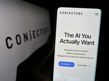 Stuttgart, Almanya - 02-19-2024: İngiliz Yapay Zeka Şirketi Varsayım Şirketi Conjecture Limited 'in web sayfası ile cep telefonu tutan kişi. Telefon ekranının merkezine odaklan.
