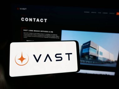 Stuttgart, Almanya - 02-21-2024: ABD 'li havacılık şirketi VAST Space LLC' nin logosuna sahip cep telefonu sahibi kişi iş sayfası önünde. Telefon ekranına odaklan.