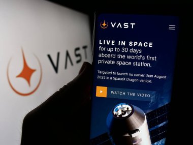 Stuttgart, Almanya - 02-21-2024: ABD 'li havacılık şirketi VAST Space LLC' nin web sayfası ile iş logosu önünde cep telefonu tutan kişi. Telefon ekranının merkezine odaklan.