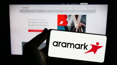 Stuttgart, Almanya - 02-22-2024: ABD 'li gıda hizmetleri ve tesis yönetimi şirketi Aramark' ın logosunun bulunduğu akıllı telefon sahibi kişi web sitesi önünde. Telefon ekranına odaklan.