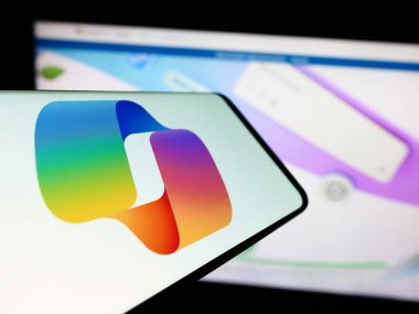 Stuttgart, Almanya - 02-22-2024: Yapay zeka sohbet robotu logosuna sahip cep telefonu Microsoft Copilot iş sitesinin önünde. Telefon ekranının merkezine odaklan.