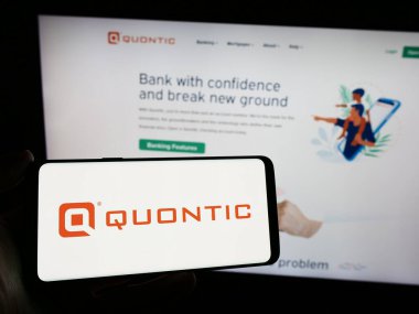 Stuttgart, Almanya - 02-23-2024: ABD 'li finans hizmetleri şirketi Quontic Bank' ın logosunun bulunduğu akıllı telefon sahibi kişi web sitesi önünde. Telefon ekranına odaklan.
