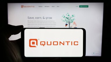 Stuttgart, Almanya - 02-23-2024: ABD 'li finans hizmetleri şirketi Quontic Bank' ın logosuyla cep telefonu sahibi kişi iş sayfası önünde. Telefon ekranına odaklan.