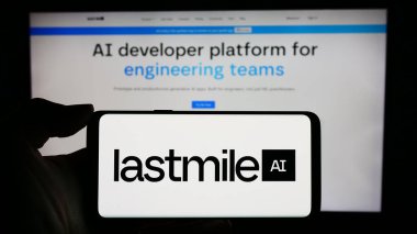 Stuttgart, Almanya - 02-24-2024: ABD 'li yapay zeka şirketi LastMile AI Inc.' in logosuyla cep telefonu sahibi kişi iş sayfasının önünde. Telefon ekranına odaklan.