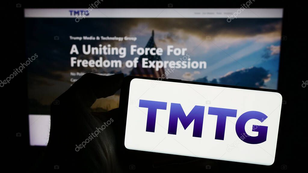 Stuttgart, Germany - 02-22-2024: Person holding cellphone with logo of US company Trump Media Technology Group (TMTG) in front of business webpage. Focus on phone display.
