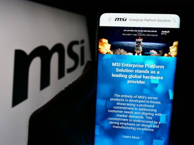 Stuttgart, Almanya - 02-24-2024: Tayvanlı Micro-Star International Co. Ltd. (MSI) şirketinin logolu web sayfası ile cep telefonu tutan kişi. Telefon ekranının merkezine odaklan.
