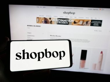 Stuttgart, Almanya - 02-24-2024: İnternet sitesi önünde ABD 'li e-ticaret moda şirketi BOP LLC' nin (Shopbop) logosuna sahip kişi. Telefon ekranına odaklan.