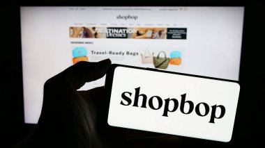 Stuttgart, Almanya - 02-24-2024: İnternet sayfası önünde üzerinde Amerikan e-ticaret şirketi BOP LLC (Shopbop) logosu olan cep telefonu sahibi kişi. Telefon ekranına odaklan.