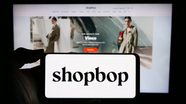 Stuttgart, Almanya - 02-24-2024: İş sayfası önünde ABD 'li e-ticaret moda şirketi BOP LLC' nin (Shopbop) logosuna sahip cep telefonu sahibi kişi. Telefon ekranına odaklan.