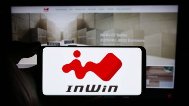 Stuttgart, Almanya - 02-24-2024: İnternet sayfası önünde Tayvanlı bilgisayar donanım şirketi InWin Development Inc. 'in logosuyla cep telefonu tutan kişi. Telefon ekranına odaklan.