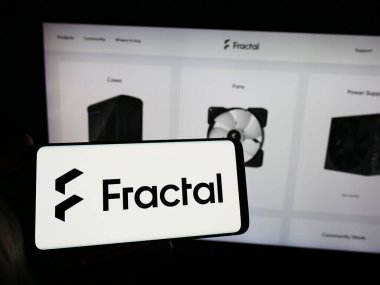 Stuttgart, Almanya - 02-24-2024: İsveçli bilgisayar donanım tasarım şirketi Fractal Gaming AB 'nin logosuna sahip cep telefonu sahibi kişi web sayfasının önünde. Telefon ekranına odaklan.