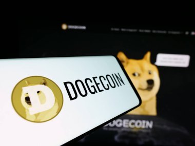 Stuttgart, Almanya - 02-26-2024: Sitenin önünde şifreli Dogecoin logosu bulunan akıllı telefon. Telefon ekranının merkez soluna odaklan.