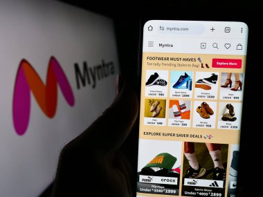 Stuttgart, Almanya - 02-29-2024: Hint e-ticaret şirketi Myntra Designs Onbaşı 'nın internet sayfası ile cep telefonu tutan kişi Ltd. Logonun önünde. Telefon ekranının merkezine odaklan.