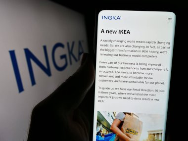 Stuttgart, Almanya - 03-01-2024: Hollandalı şirket INGKA Holding B.V. 'nin web sitesi ile iş logosu önünde akıllı telefon tutan kişi. Telefon ekranının merkezine odaklan.
