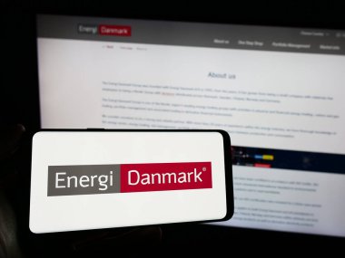 Stuttgart, Almanya - 03-01-2024: Danimarkalı enerji ticareti şirketi Energi Danmark AS 'nin logosunu taşıyan cep telefonu sahibi kişi iş sayfasının önünde. Telefon ekranına odaklan.