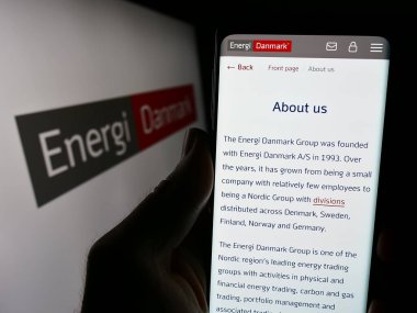 Stuttgart, Almanya - 03-01-2024: Danimarkalı enerji ticareti şirketi Energi Danmark AS 'nin logo önündeki web sayfası ile akıllı telefon tutan kişi. Telefon ekranının merkezine odaklan.