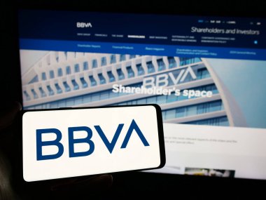 Stuttgart, Almanya - 03-01-2024: İnternet sitesi önünde Banco Bilbao Vizcaya Argentaria S.A. (BBVA) şirketinin logosuna sahip kişi. Telefon ekranına odaklan.