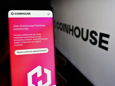 Stuttgart, Almanya - 03-14-2024: Logonun önünde Fransız kripto yatırım şirketi Coinhouse SAS 'ın web sayfası ile akıllı telefon tutan kişi. Telefon ekranının merkezine odaklan.