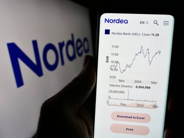 Stuttgart, Almanya - 03-15-2024: Fin finans hizmetleri şirketi Nordea Bank Abp 'in internet sayfası ile logo önünde cep telefonu tutan kişi. Telefon ekranının merkezine odaklan.