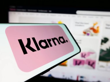Stuttgart, Almanya - 03-16-2024: İsveçli fintech şirketi Klarna Bank AB 'nin logosunun bulunduğu cep telefonu, işletme web sitesi önünde. Telefon ekranının merkez soluna odaklan.