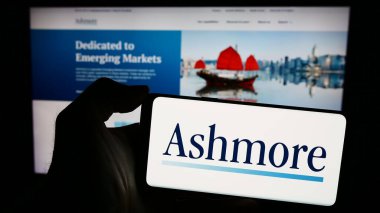 Stuttgart, Almanya - 03-16-2024: İngiliz yatırım şirketi Ashmore Group plc 'in logosuna sahip akıllı telefon sahibi kişi web sitesinin önünde. Telefon ekranına odaklan.
