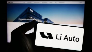 Stuttgart, Almanya - 03-16-2024: Çinli elektrikli araç şirketi Li Auto Inc. 'in logosuna sahip akıllı telefon sahibi kişi web sitesinin önünde. Telefon ekranına odaklan.