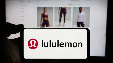 Stuttgart, Almanya - 03-16-2024: İnternet sayfasının önünde Kanadalı giyim perakende şirketi Lululemon Athletica Inc. 'in logosu olan cep telefonu sahibi kişi. Telefon ekranına odaklan.