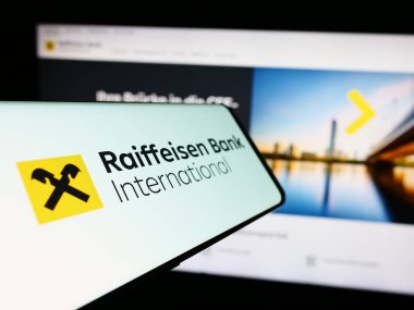 Stuttgart, Almanya - 03-16-2024: Avusturyalı firma Raiffeisen Bank International AG (RBI) logosuna sahip akıllı telefon web sitesinin önünde. Telefon ekranının merkez soluna odaklan.