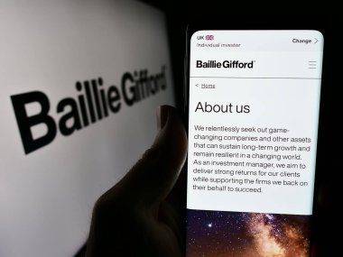 Stuttgart, Almanya - 03-17-2024: İngiliz yatırım şirketi Baillie Gifford Co. 'nun logolu web sayfası ile cep telefonu tutan kişi. Telefon ekranının merkezine odaklan.