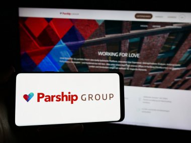 Stuttgart, Almanya - 03-17-2024: İnternet sitesi önünde Alman randevu şirketi ParshipMeet Holding GmbH 'nin logosuna sahip kişi. Telefon ekranına odaklan.