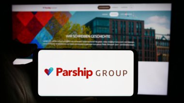 Stuttgart, Almanya - 03-17-2024: Alman randevu şirketi ParshipMeet Holding GmbH 'nin logosuyla cep telefonu tutan kişi iş sayfası önünde. Telefon ekranına odaklan.