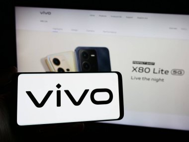 Stuttgart, Almanya - 03-17-2024: Çinli şirket Vivo Communication Technology Co. Ltd. nin logosuna sahip akıllı telefon sahibi kişi web sitesinin önünde. Telefon ekranına odaklan.