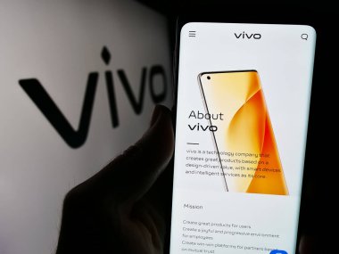 Stuttgart, Almanya - 03-17-2024: Çinli Vivo Communication Technology Co. Ltd. logolu cep telefonu sahibi kişi. Telefon ekranının merkezine odaklan.