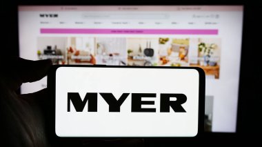Stuttgart, Almanya - 03-05-2024: Avustralyalı perakende şirketi Myer Holding Ltd. 'nin logosuyla cep telefonu tutan kişi iş sayfasının önünde. Telefon ekranına odaklan.