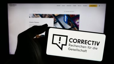 Stuttgart, Almanya - 03-05-2024: Üzerinde Correctiv logosu olan cep telefonu sahibi kişi - Recherchen kürkü die Gesellschaft gGGmbH web sayfasının önünde. Telefon ekranına odaklan.