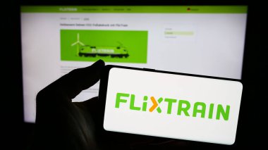 Stuttgart, Almanya - 03-05-2024: İnternet sitesi önünde Alman uzun mesafe demiryolu şirketi FlixTrain 'in logosuna sahip kişi. Telefon ekranına odaklan.