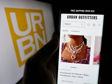 Stuttgart, Almanya - 03-06-2024: Logo önünde ABD 'li hızlı moda şirketi Urban Outfitters Inc. (URBN)' in internet sitesi olan kişi. Telefon ekranının merkezine odaklan.