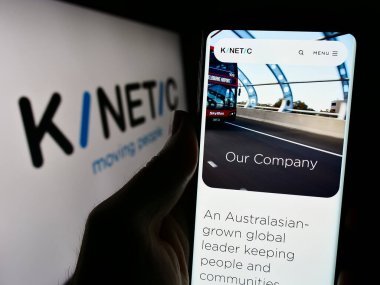 Stuttgart, Almanya - 03-06-2024: Avustralyalı hareketlilik şirketi Kinetic Group 'un web sayfası ile iş logosu önünde cep telefonu tutan kişi. Telefon ekranının merkezine odaklan.