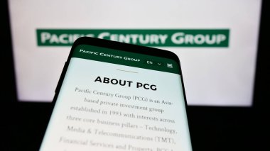 Stuttgart, Almanya - 03-07-2024: Yatırım şirketi Pacific Century Group 'un (PCG) web sitesi ile ticaret logosu önünde akıllı telefon. Telefon ekranının sol üst kısmına odaklan.