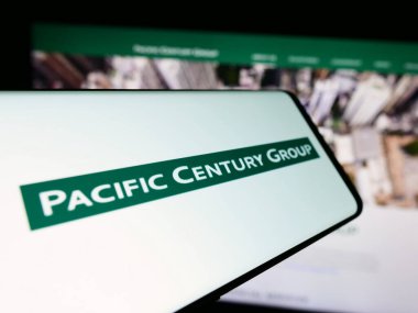 Stuttgart, Almanya - 03-07-2024: Pacific Century Group (PCG) yatırım şirketinin logosuna sahip cep telefonu. Telefon ekranının merkez soluna odaklan.