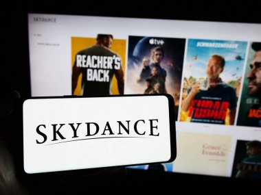 Stuttgart, Almanya - 03-07-2024: ABD 'li film yapım şirketi Skydance Media LLLC' nin logosuyla cep telefonu tutan kişi iş sayfasının önünde. Telefon ekranına odaklan.