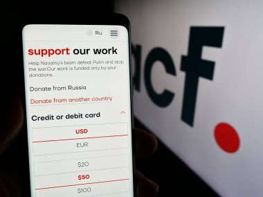 Stuttgart, Almanya - 03-07-2024: Rus Yolsuzlukla Mücadele Vakfı 'nın (ACF) logolu web sayfası ile akıllı telefon tutan kişi. Telefon ekranının merkezine odaklan.