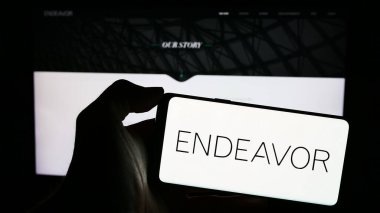 Stuttgart, Almanya - 03-07-2024: ABD 'li yetenek ajansı Endeavor Group Holding Inc.' nin logosuyla cep telefonu sahibi kişi iş sayfasının önünde. Telefon ekranına odaklan.