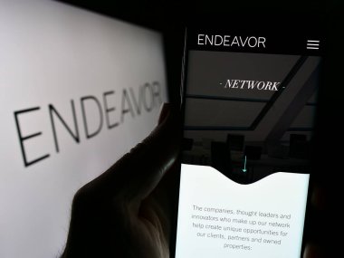 Stuttgart, Almanya - 03-07-2024: ABD 'li yetenek ajansı Endeavor Group Holding Inc.' nin web sitesi ile logo önünde cep telefonu tutan kişi. Telefon ekranının merkezine odaklan.