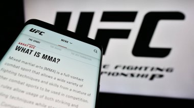 Stuttgart, Almanya - 03-07-2024: Logo önünde dövüş sanatları firması Ultimate Fighting Championship (UFC) web sitesi ile cep telefonu. Telefon ekranının sol üst kısmına odaklan.