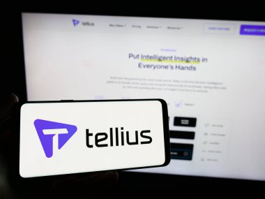 Stuttgart, Germany - 03-08-2024: Person holding smartphone with logo of US artificial intelligence analytics company Tellius Inc. in front of website. Focus on phone display. clipart