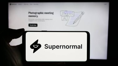 Stuttgart, Almanya - 03-08-2024: ABD 'li AI şirketi Supernormal Technologies Inc.' nin logosuyla cep telefonu bulunduran kişi iş sayfasının önünde. Telefon ekranına odaklan.