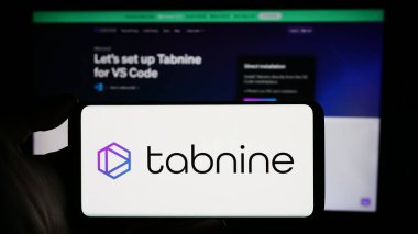 Stuttgart, Almanya - 03-08-2024: İsrailli AI kodlama şirketi Tabnine Ltd. 'nin logosuyla cep telefonu tutan kişi iş sayfasının önünde. Telefon ekranına odaklan.
