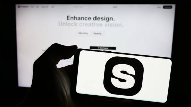 Stuttgart, Almanya - 03-08-2024: Web sayfasının önünde yapay zeka imge üretim şirketi Stockimg Al 'in logosuna sahip cep telefonu sahibi kişi. Telefon ekranına odaklan.